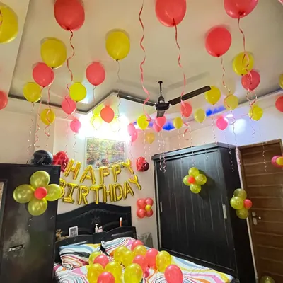 A classic birthday room surprise. I filled the room with colorful balloons, hung some from the ceiling with ribbons, and placed a "Happy Birthday" foil banner right above the bed to create a festive welcome.