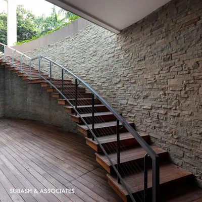 This outdoor staircase combines the warmth of wooden treads with the raw texture of a stone wall, creating a beautiful and durable transition to an entertainment area.