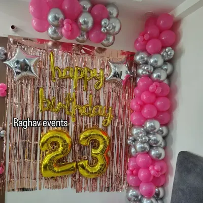 A beautiful wall decoration for a 23rd birthday. This setup features a pink and silver balloon arrangement, a rose gold shimmer curtain, 'Happy Birthday' foil letters, and large number '23' foil balloons.