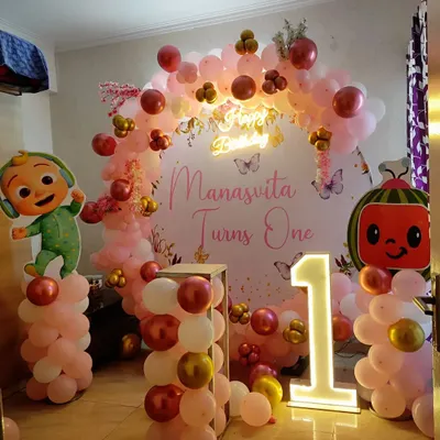 A Cocomelon theme is a favorite for first birthdays. Here, I created a full party backdrop for 'Manasvita Turns One' with character cut-outs, a pink and rose gold balloon arch, and a large light-up number '1'.