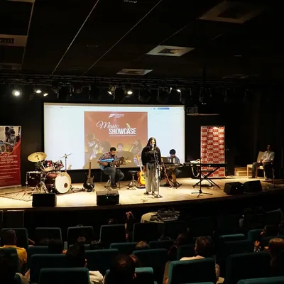 A wide shot of our student music showcase in Thane, with a full band on stage performing for a packed auditorium. These recitals are a core part of our curriculum, giving students a professional platform to demonstrate their skills.