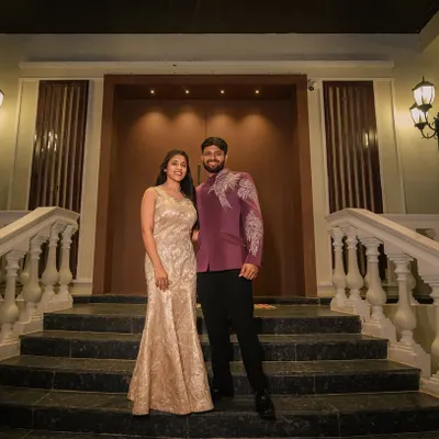 A beautiful portrait of a couple dressed in my custom designs. His plum Indo-Western jacket with silver embroidery perfectly complements her elegant champagne-colored mermaid gown.
