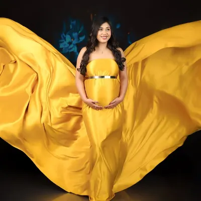 Feel like a goddess with my artistic fabric draping. This vibrant yellow fabric is expertly styled to create a breathtaking "wings" effect for a truly epic maternity photo.