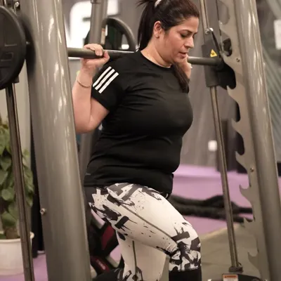 A member performs lunges on the Smith machine, a great exercise for targeting the quads and glutes with added stability and control.