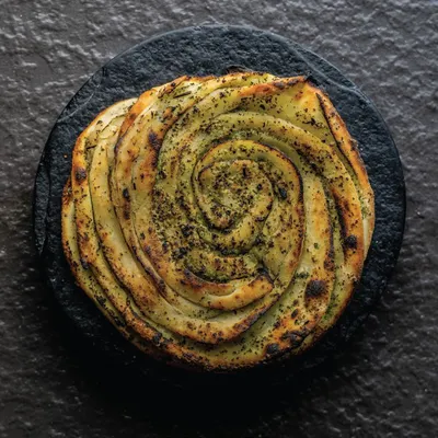 This beautifully swirled pesto bread represents our journey and our core belief in gourmet dining at home. It's a symbol of our growth and commitment to culinary excellence.