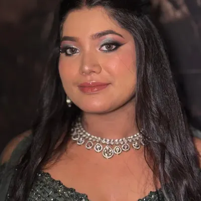 A direct, confident portrait showcasing a dramatic smokey eye. The intense eye makeup is balanced with glossy lips and glowing skin for a powerful yet feminine look.