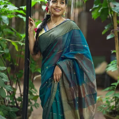 A model looking fresh and radiant in a teal blue Maheshwari silk cotton saree. The subtle stripes and lightweight fabric make it an ideal choice for comfortable, all-day wear.