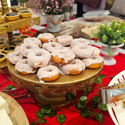 A golden stand adorned with my sugar-glazed mini donuts. These soft, sweet treats are a delightful addition to any dessert table and a favorite among all age groups.