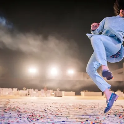 A groom's friend leaps in the air during an energetic sangeet dance performance. I capture these high-energy, candid moments that show the pure joy and fun of the celebration.