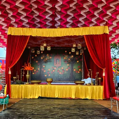 This is a classic stage design with a theatrical feel, using heavy red curtains and a decorative backdrop. The setup is ideal for cultural programs, award ceremonies, or traditional performances that require a formal and elegant setting.