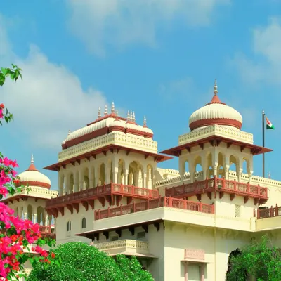 The majestic exterior of the Rambagh Palace Hotel. The architecture, with its intricate 'chhatris', arched windows, and grand domes, was carefully preserved during its conversion to a hotel, maintaining the authentic look and feel of its royal past.
