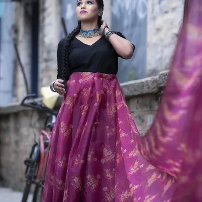 This is a modern fusion look, pairing a simple black top with a vibrant floral skirt. I styled the hair in a long, thick braid and used contemporary silver jewellery to complete this chic, indo-western outfit.