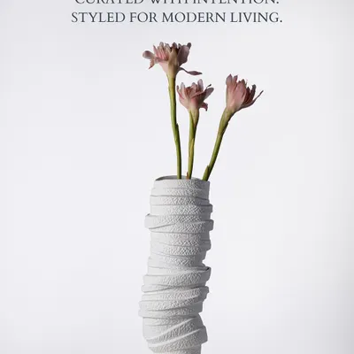 Curated with intention, styled for modern living. This white textured vase, holding delicate pink lilies, embodies the Faaya Focus ethos. Its wrapped, sculptural form adds a layer of artistry, making it a statement piece that feels both contemporary and timeless.
