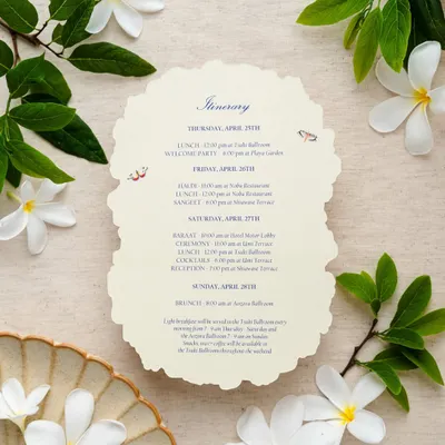 An elegant, laser-cut itinerary card with a scalloped edge. The design is simple and classic, with beautiful typography and two small, illustrated birds adding a touch of personality.