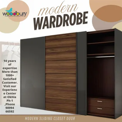 Sliding door wardrobes are a perfect solution for rooms where space is tight, as they don't require room to swing open. This design combines a dark grey finish with a textured wood panel, creating a sophisticated and modern look.