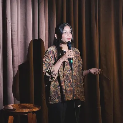 On stage at an open mic, sharing my poetry. This is where I connect with people on a different level, using shayari to express the same passion I bring to the law.