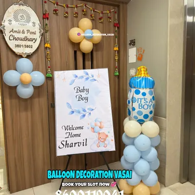A sweet and simple "Welcome Home" setup for baby Sharvil. This decoration includes a personalized welcome sign, a balloon pillar with a baby bottle foil balloon, and small balloon clusters to adorn the entrance.