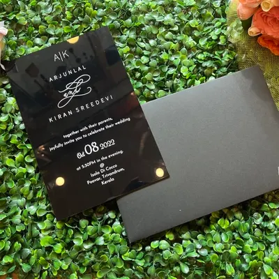 A bold and modern choice. This sleek black acrylic invitation features white screen-printed text and a custom monogram, paired with a matching black envelope.