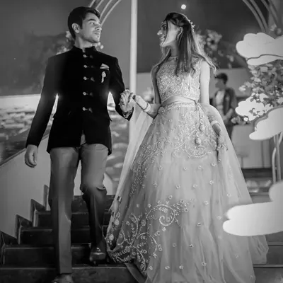 A timeless black and white photograph of the couple making their entrance at their engagement ceremony. This classic style emphasizes the elegance of the moment.