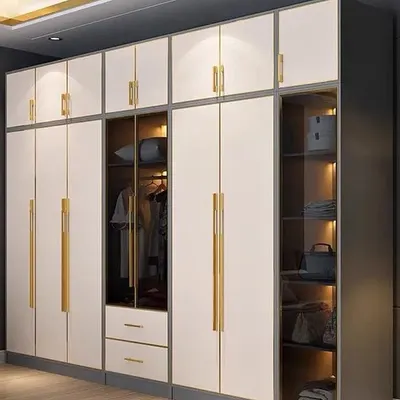 A floor-to-ceiling wardrobe in white and gold, featuring a mix of closed cabinets, drawers, and a glass display section. This design offers extensive storage while adding a touch of luxury to the bedroom.