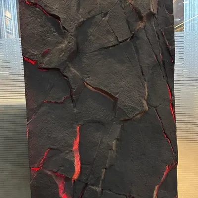 A close-up of our PU stone panel with integrated red backlighting. This creates a dramatic effect, highlighting the rugged texture of the stone.