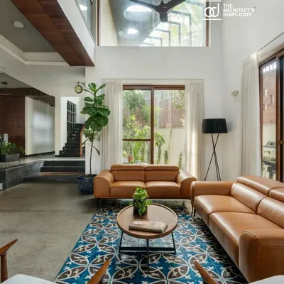 The main living area is the heart of 'Jodi Mane', defined by its grand double-height ceiling and expansive windows. This design choice was crucial for passive cooling and creating a powerful connection to the outdoors, a central theme of the project.