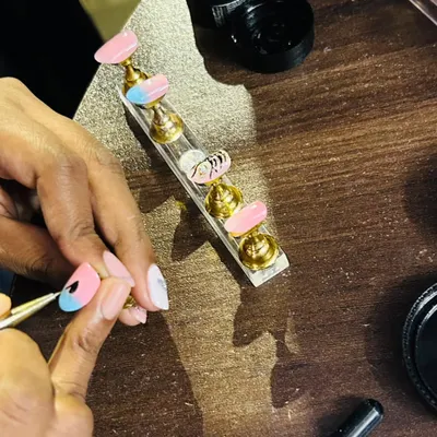 A glimpse into my workspace. Here I am, carefully hand-painting the details on a lotus-themed nail set. Every single nail gets my full attention to ensure it's perfect.