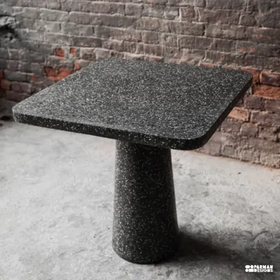 This beautiful black terrazzo cafe table, with its clean lines and monolithic form, was designed in collaboration with Loop Design Studio. It's a perfect example of how a simple shape can make a strong statement.