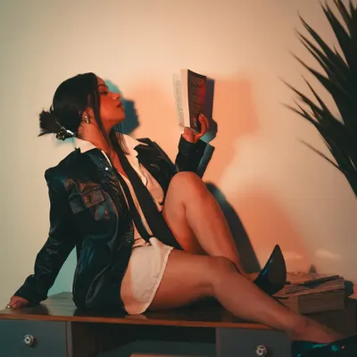 We continued the 'Boss Lady' concept with this shot, using a book as a prop to add to the character's story. The warm, focused light creates an intimate yet powerful atmosphere.