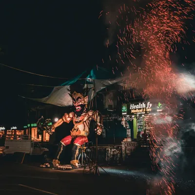 A giant effigy of the demon Narakasura stands on a Goan street during Diwali, with sparks from a firecracker flying in the foreground.