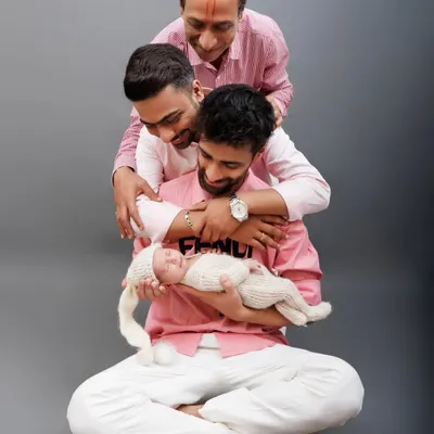 Three generations of love in one frame. This portrait of a baby with his father, uncle, and grandfather is a powerful tribute to family bonds. We shot this in the studio for a clean, timeless look.
