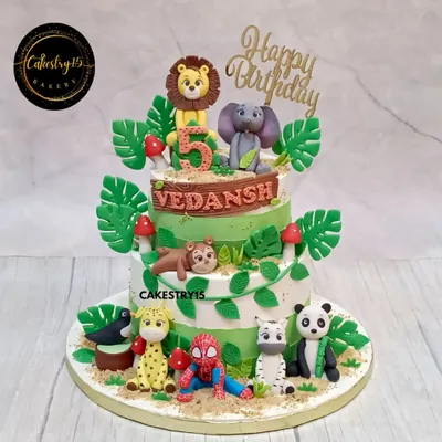 A fun two-tier jungle cake with a superhero twist. This chocolate cake features a variety of fondant jungle animals alongside a surprise appearance by Spiderman.