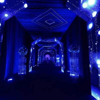 I designed this immersive tunnel entrance with dynamic LED walls and a geometric ceiling to feel like a portal to the party, setting a futuristic tone from the start.