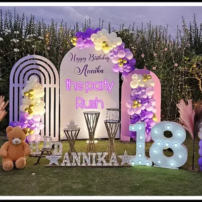 For Annika's 18th birthday, I designed this elegant outdoor setup with a purple and white color scheme. The decor features modern arched backdrops, soft balloon arrangements, and large marquee numbers to mark the special milestone.
