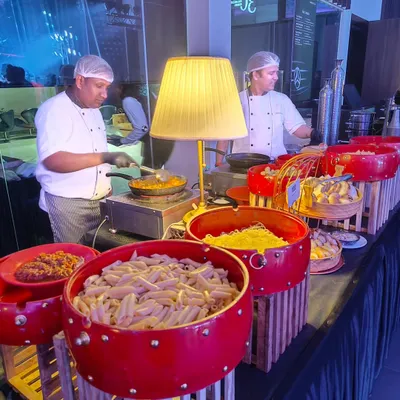 Our chefs at a live pasta station during the launch of the Mercedes EQ. The setup, featuring our signature red bowls and elegant table lamps, is designed to integrate seamlessly with the client's sophisticated brand aesthetic.