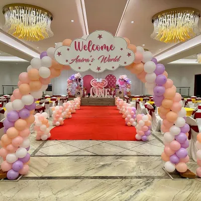 A grand entrance for a first birthday, creating a 'wow' factor right from the start. A massive balloon arch leads guests down a red carpet to the main stage, setting the scene for a spectacular event.