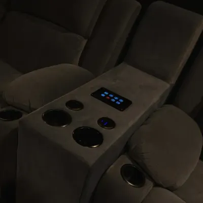 A key part of a seamless home theater is integrating controls where you need them most. This image shows a smart panel built directly into the center console of the recliner seats.