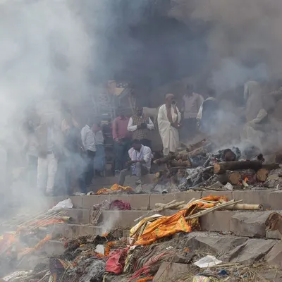Smoke from cremation pyres fills the air at Manikarnika Ghat. This documentary photo captures the intensity of the final rites, a powerful part of the journey towards moksh.