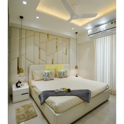 This master bedroom at Tata La Vida, Gurugram, is the epitome of serenity. The full-height upholstered headboard features an asymmetrical geometric pattern with gold metal inlays, creating a stunning and luxurious focal point.