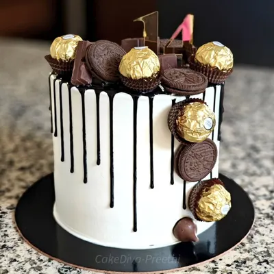 A little too much chocolate is just about right! This tall drip cake is frosted with white buttercream, has a rich black chocolate drip, and is loaded with Ferrero Rochers, Oreos, and chocolate bars.