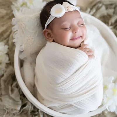 A heart-melting smile from a baby dreaming in a cozy white wrap. These are the precious, spontaneous moments I watch for during every session.