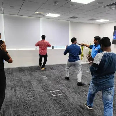Leading a Tai Chi session for a corporate team. I guide participants through gentle, flowing movements designed to improve posture, balance, and mindfulness in the workplace.