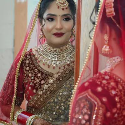 A quiet moment of reflection for the bride before she steps into her new chapter. This classic red and gold bridal makeup is designed to be both bold and elegant, perfectly complementing her traditional attire.