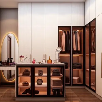 This walk-in closet combines open and closed storage for ultimate functionality. The design features glass-front drawers and cabinets with internal lighting, a dedicated vanity station, and ample hanging space.