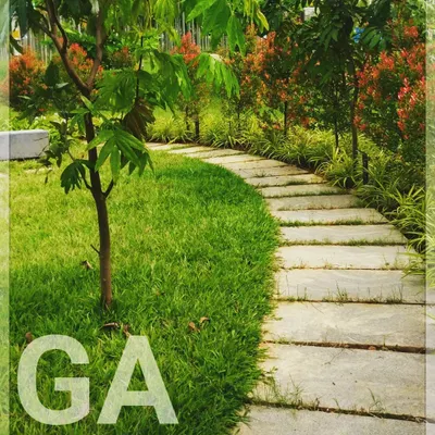 A simple garden path made from natural stone slabs, set into a lush lawn. This detail from a farmland project shows our belief that the journey through a garden should be as beautiful as the destination.