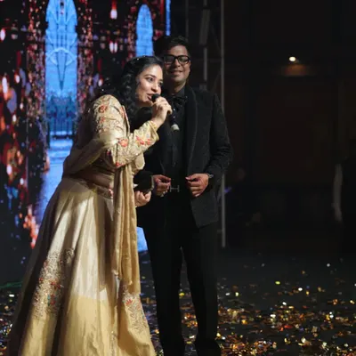 On stage during a grand Sangeet night. With a dazzling backdrop and a mic in hand, I'm ready to get the performances started and keep the energy high all night long.