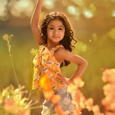 Capturing the pure joy and confidence of childhood. This shot, set against a projected background of a sun-drenched flower field, is full of life, color, and personality.