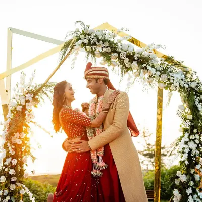 A golden hour Varmala ceremony we planned in Goa. The modern floral arch against the setting sun and the sea created an absolutely breathtaking backdrop for Aeshna and Anirudh's special moment.