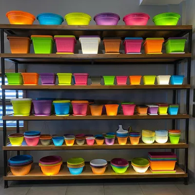 My shelves are fully stocked with a rainbow of colorful plastic planters. This image gives you an idea of the vast selection of sizes and bright colors I keep on hand, ready for you to pick from.