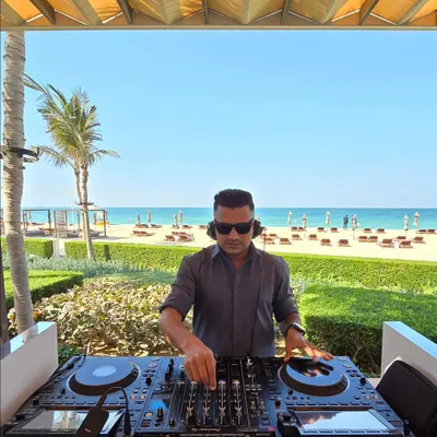 A daytime beach event requires a completely different energy. Here I am at a sundowner in Dubai, curating a relaxed yet groovy playlist as the sun sets over the ocean. It's all about matching the music to the mood.
